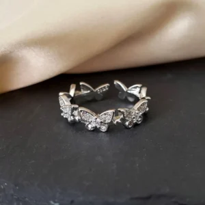 Silver adjustable ring featuring multiple sparkling butterfly designs with crystal accents, perfect for stylish everyday wear.