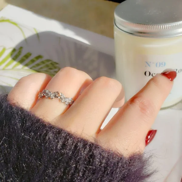 Silver adjustable ring featuring multiple sparkling butterfly designs with crystal accents, perfect for stylish everyday wear.