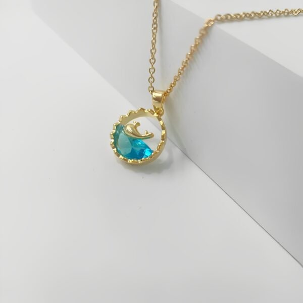 Side angle of gold whale pendant showing gemstone shine