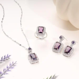 Silver-plated jewelry set with purple gemstone and white crystals – necklace, earrings, and ring.