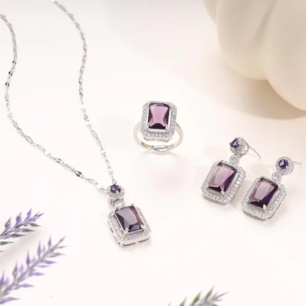 Silver-plated jewelry set with purple gemstone and white crystals – necklace, earrings, and ring.
