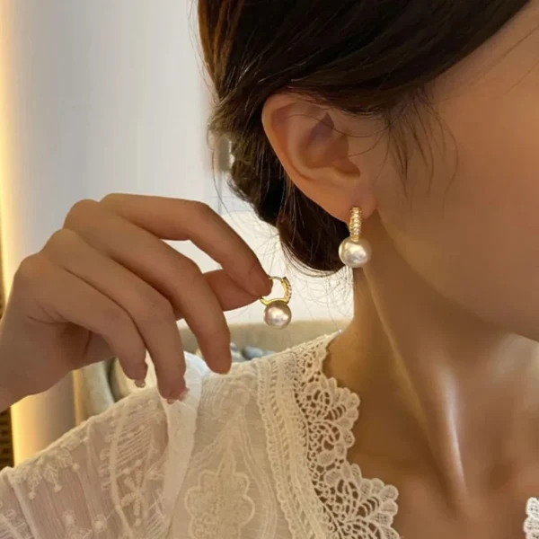 Gold-plated hoop earrings with pearl drop and crystal accents – luxury fashion jewelry.