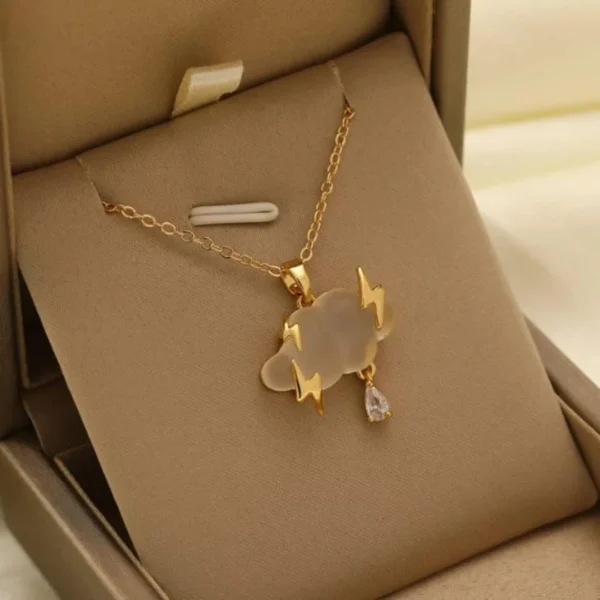 Gold chain necklace with a matte cloud pendant, gold lightning bolts, and a crystal raindrop charm.