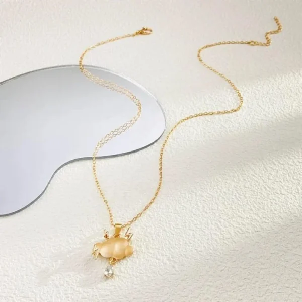 Gold chain necklace with a matte cloud pendant, gold lightning bolts, and a crystal raindrop charm.