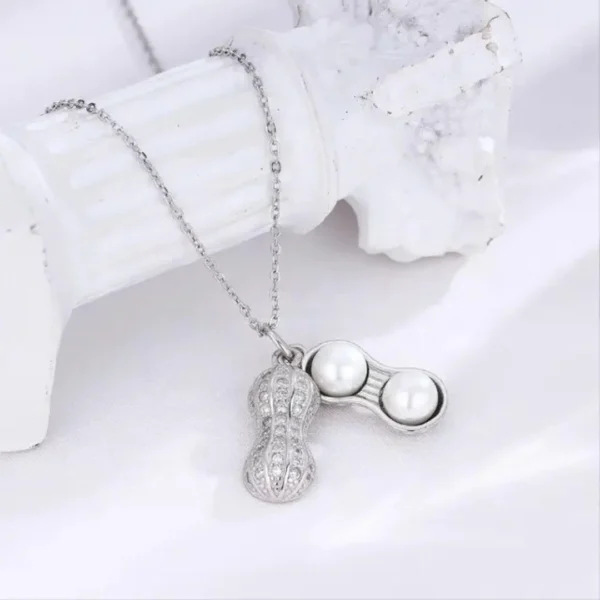 Silver necklace with a peanut-shaped pendant featuring twin pearls inside a textured metallic shell design