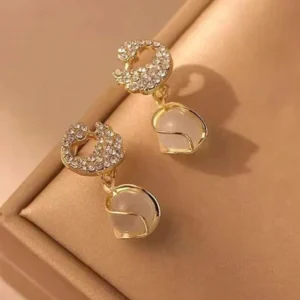 Gold earrings with crystal-studded crescent moons and opal-style dangling drops – celestial party jewelry