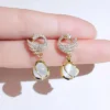 Gold earrings with crystal-studded crescent moons and opal-style dangling drops – celestial party jewelry