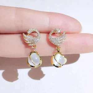 Gold earrings with crystal-studded crescent moons and opal-style dangling drops – celestial party jewelry
