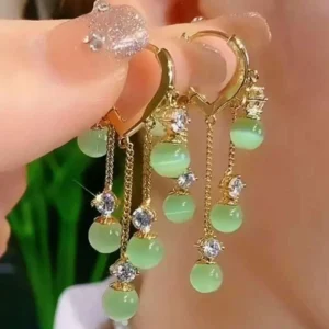 Gold hoop earrings with dangling green beads and crystal drops – statement fashion jewelry for women