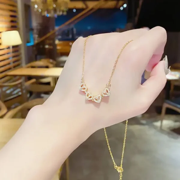 Gold-plated clover-shaped necklace with sparkling white stones and intricate floral heart design