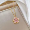 Gold chain necklace with a pink flower-shaped pendant made of teardrop crystals and surrounded by tiny white stones