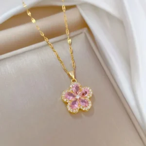 Gold chain necklace with a pink flower-shaped pendant made of teardrop crystals and surrounded by tiny white stones