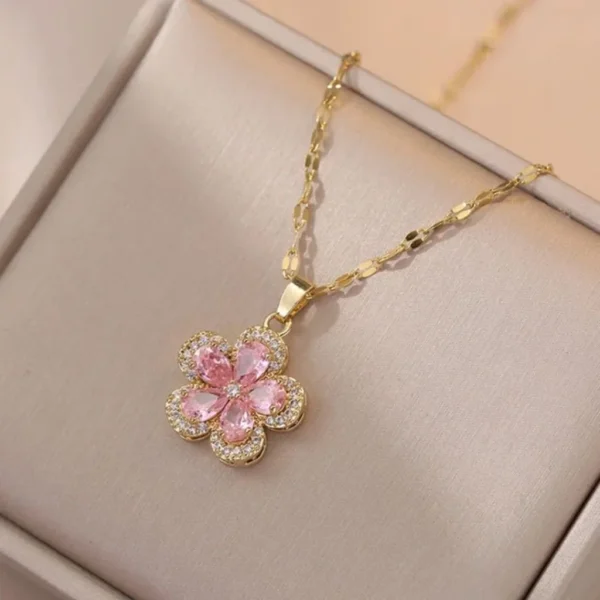 Gold chain necklace with a pink flower-shaped pendant made of teardrop crystals and surrounded by tiny white stones