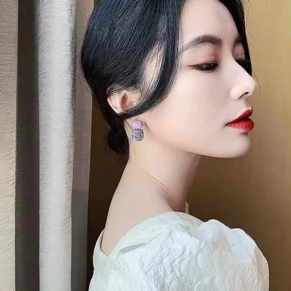Model wearing purple party earrings