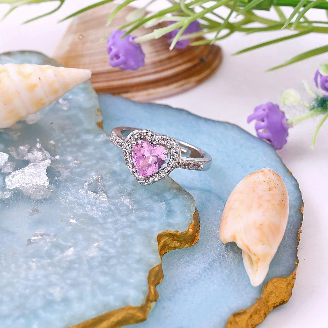 Silver ring with a pink heart-shaped center stone surrounded by micro-pave crystals, perfect for romantic, trendy everyday looks.