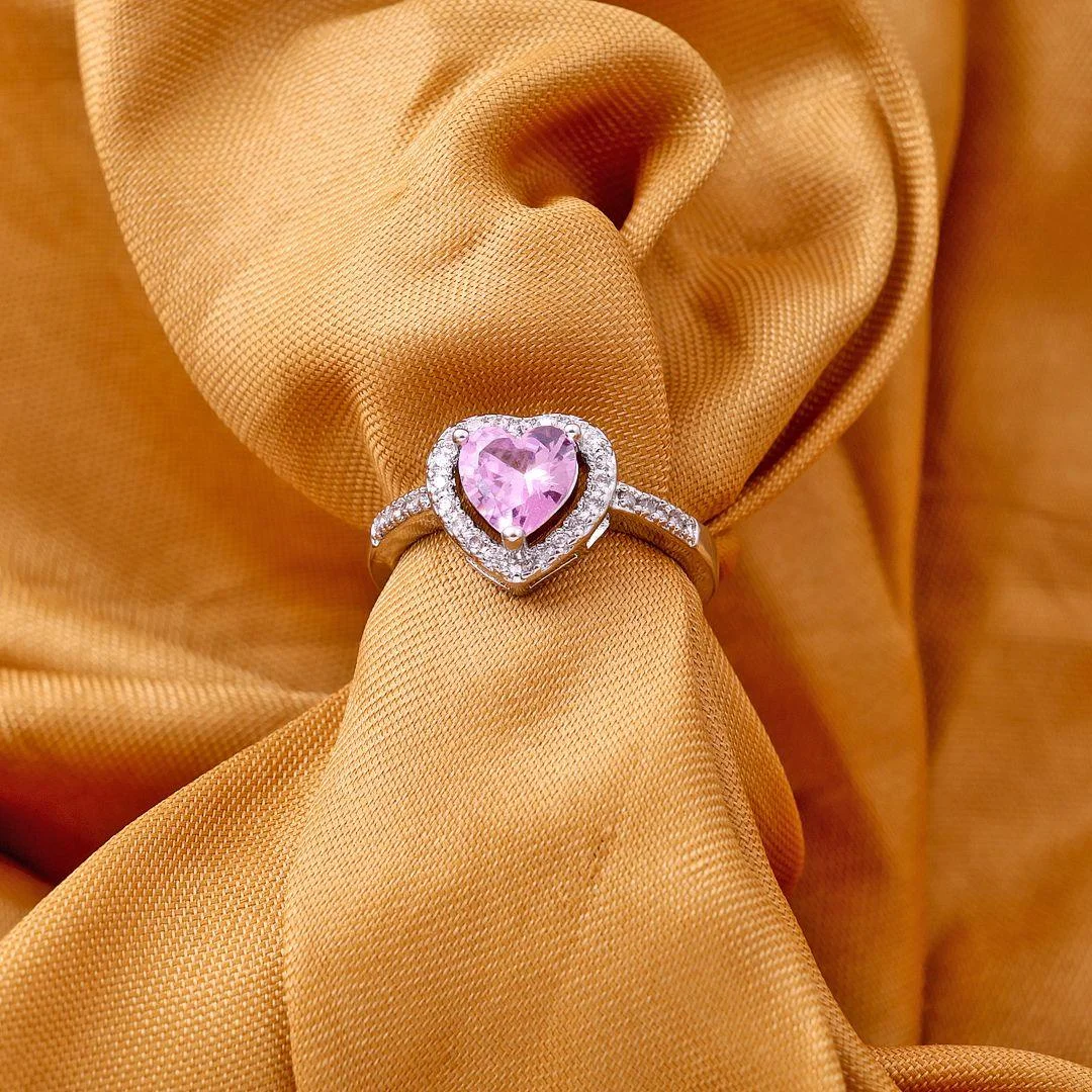 Silver ring with a pink heart-shaped center stone surrounded by micro-pave crystals, perfect for romantic, trendy everyday looks.
