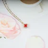 Gold plated red clover pendant necklace with crystal border – elegant, bold everyday jewelry for women.