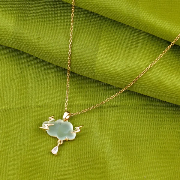 Gold-plated thundercloud pendant with lightning bolts and teardrop crystal on a light green charm.