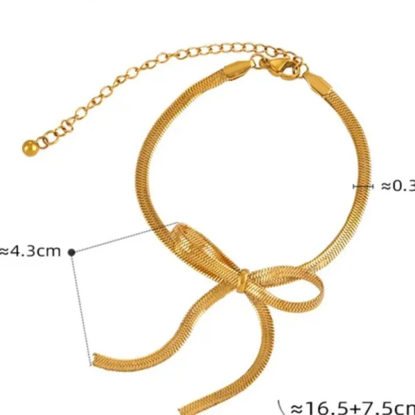 a gold bracelet with a bow on it