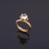 Gold plated ring with large central crystal and rhinestone-studded band, perfect for party wear or cocktail look.