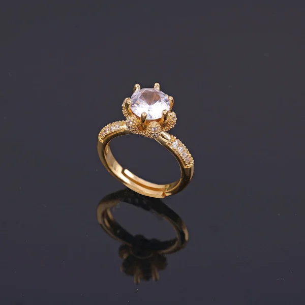 Gold plated ring with large central crystal and rhinestone-studded band, perfect for party wear or cocktail look.