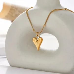 Trendy gold necklace with a smooth puffed heart-shaped pendant on a textured gold chain, perfect for everyday chic style.