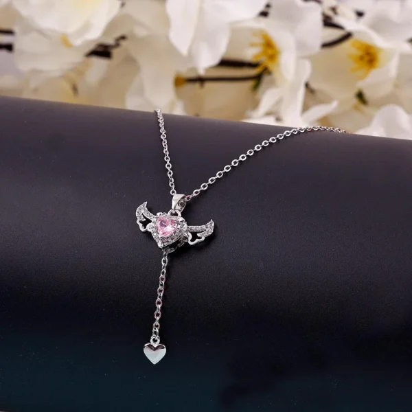 Silver chain heart pendant necklace with pink gemstone and edgy wings – bold y2k-style jewelry.