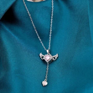 Silver chain heart pendant necklace with pink gemstone and edgy wings – bold y2k-style jewelry.