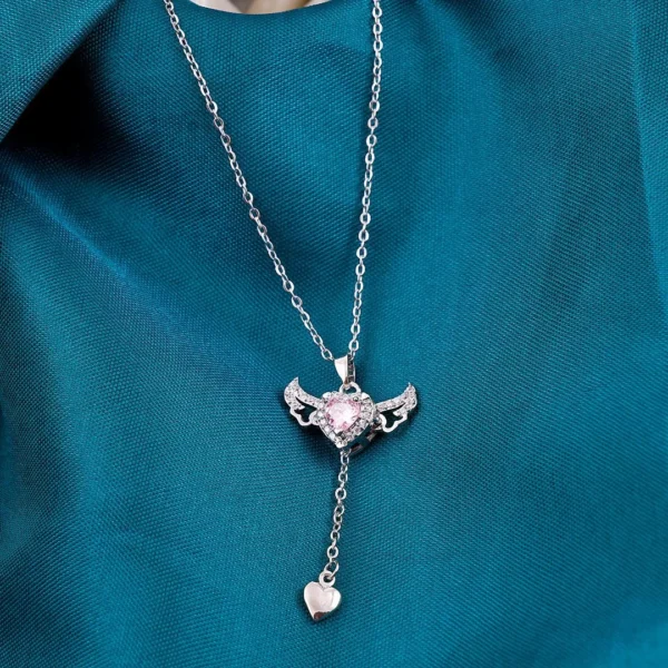 Silver chain heart pendant necklace with pink gemstone and edgy wings – bold y2k-style jewelry.