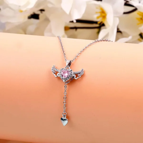 Silver chain heart pendant necklace with pink gemstone and edgy wings – bold y2k-style jewelry.
