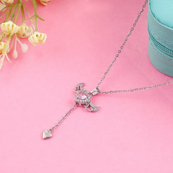 Silver chain heart pendant necklace with pink gemstone and edgy wings – bold y2k-style jewelry.