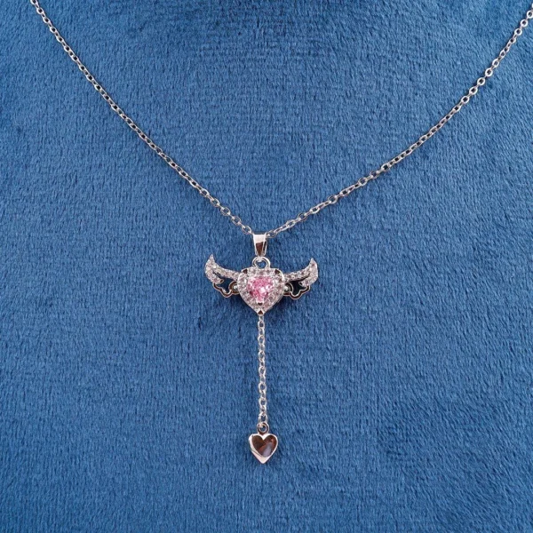 Silver chain heart pendant necklace with pink gemstone and edgy wings – bold y2k-style jewelry.