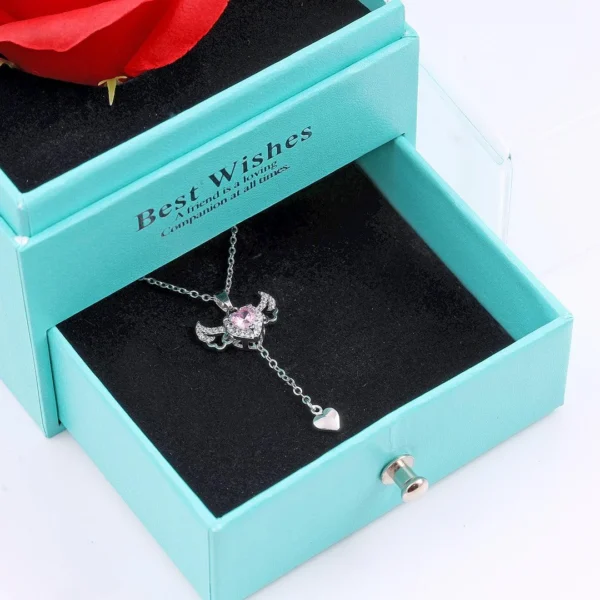 Silver chain heart pendant necklace with pink gemstone and edgy wings – bold y2k-style jewelry.