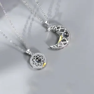 Silver couple necklace set with sun and moon themed pendants, featuring celestial cutouts and black pearls, perfect for matching jewelry.