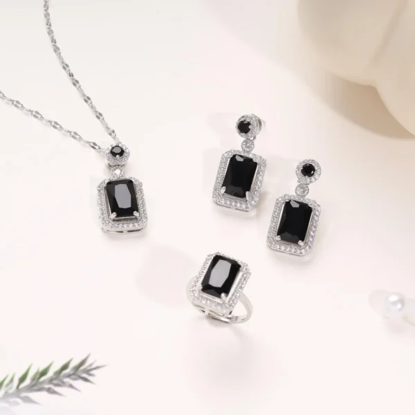 Elegant black gemstone necklace, ring, and earring set with silver-tone accents in a glamorous rectangle-cut design.