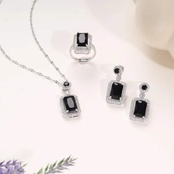 Elegant black gemstone necklace, ring, and earring set with silver-tone accents in a glamorous rectangle-cut design.