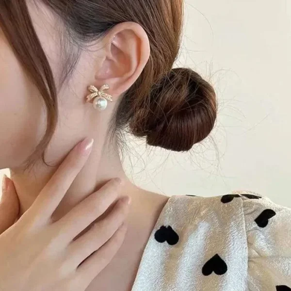 Elegant pearl stud earrings with crystal-studded gold bows – party wear jewelry for women