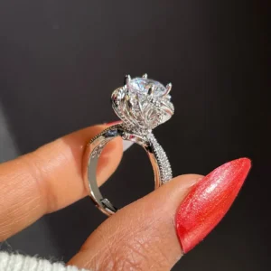 Close-up of a silver crown-shaped ring with a large central stone, luxury glam party ring for women.