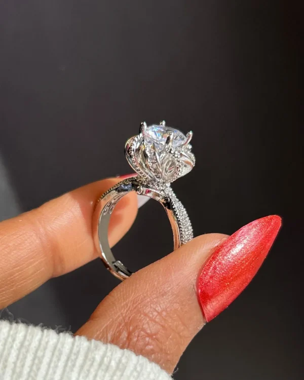 Close-up of a silver crown-shaped ring with a large central stone, luxury glam party ring for women.