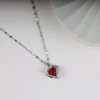 Silver chain necklace with a deep red heart-shaped crystal pendant, accented by sparkling stones – perfect for daily wear or gifting.