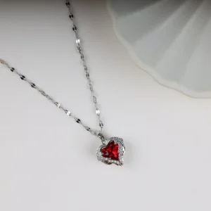Silver chain necklace with a deep red heart-shaped crystal pendant, accented by sparkling stones – perfect for daily wear or gifting.