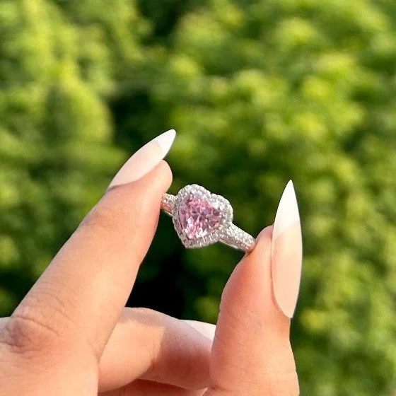 Silver ring with a pink heart-shaped center stone surrounded by micro-pave crystals, perfect for romantic, trendy everyday looks.