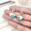 Gold-toned drop earrings with green gemstone top, blue enamel sea design and pearl accent